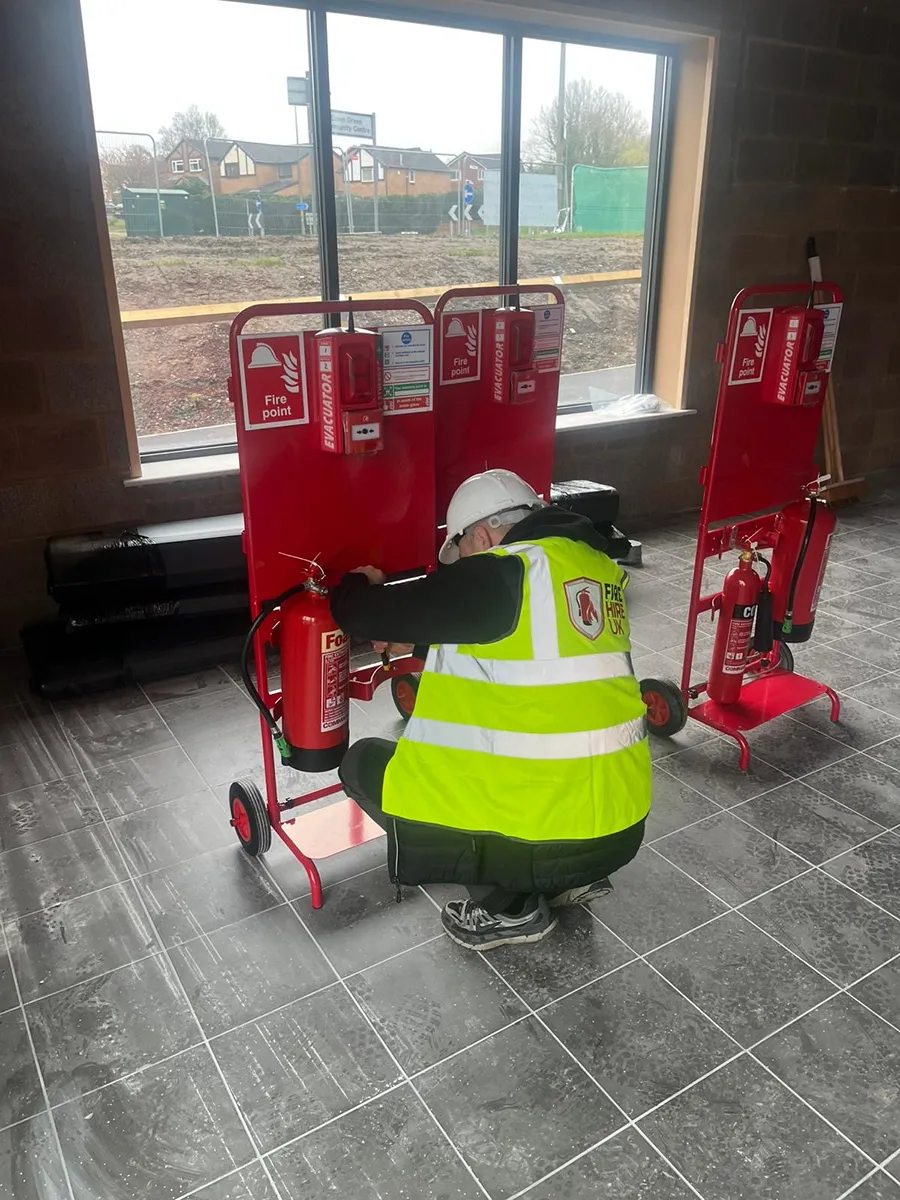 Engineer servicing fire trolleys — wide shot